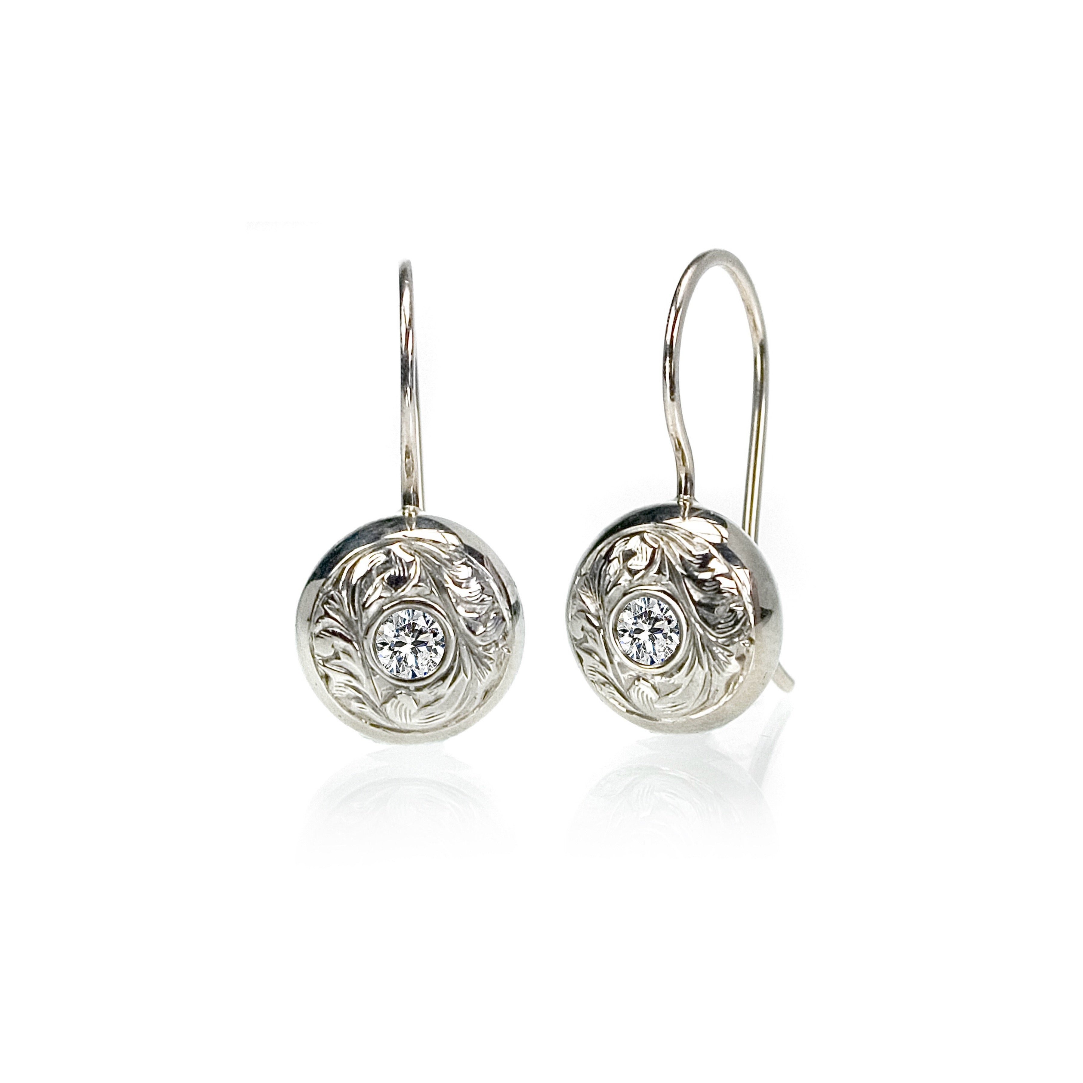 Crafted in 14KT white gold, these drop earrings feature round brilliant-cut diamonds with paisley hand-engraved halos. 