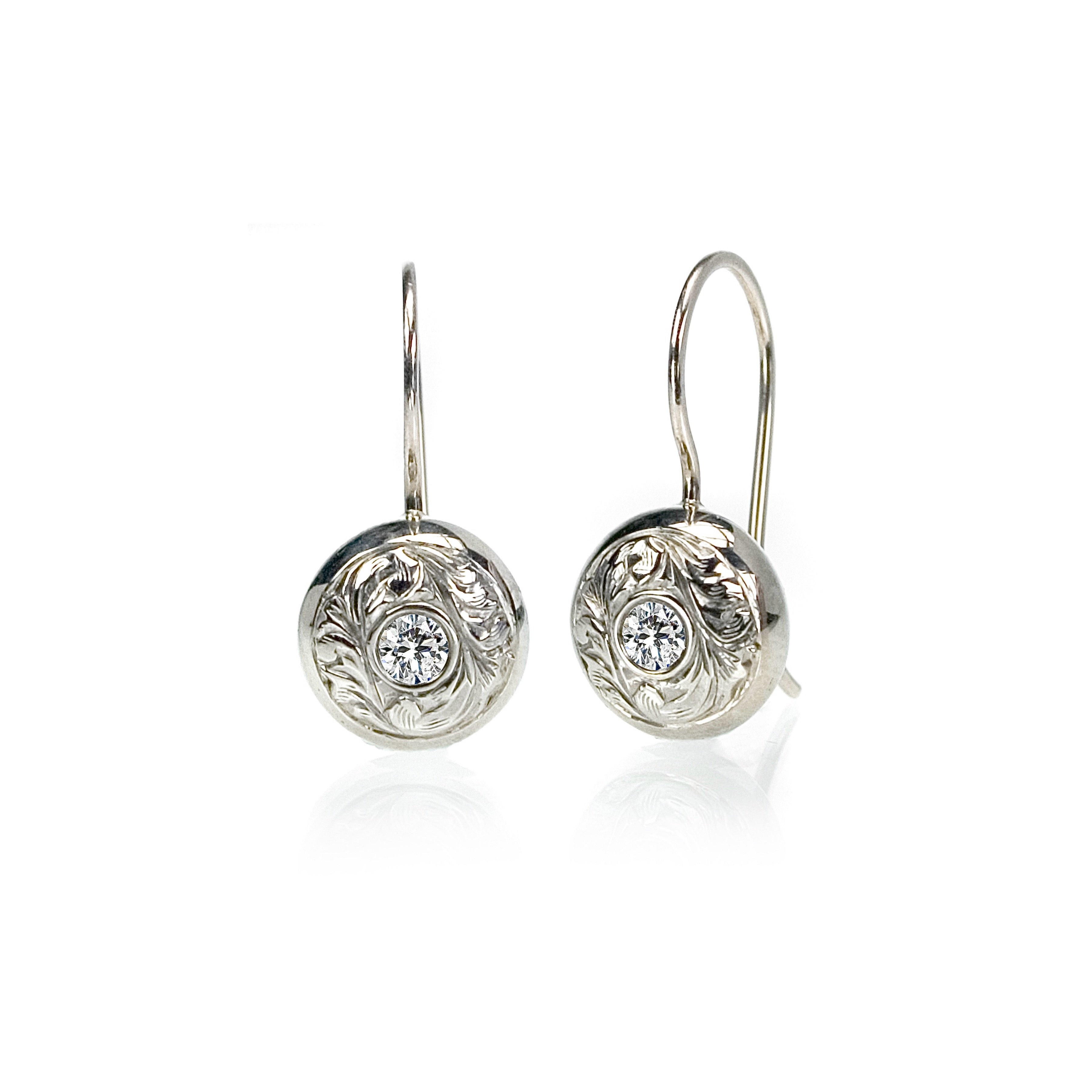 Crafted in 14KT white gold, these drop earrings feature round brilliant-cut diamonds with paisley hand-engraved halos.