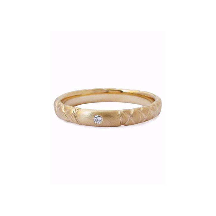 Crafted in 14KT yellow gold, this quilted band features a round brilliant-cut centre diamond.
