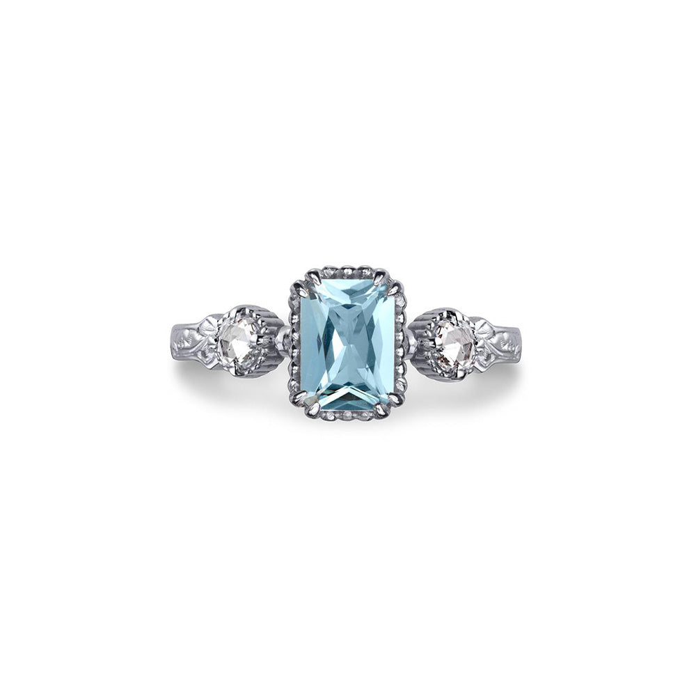 Crafted in 14KT white gold, this ring features an aquamarine between two round brilliant-cut diamonds on a vintage-inspired hand engraved band.