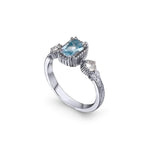 Crafted in 14KT white gold, this ring features an aquamarine between two round brilliant-cut diamonds on a vintage-inspired hand engraved band.