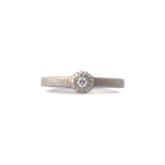 Crafted in 14KT brushed white gold, this ring features a bezel-set round brilliant-cut diamond on a flat band.