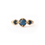 Crafted in 14KT yellow gold, this ring features a blue sapphire set between two smaller ones on a vintage-inspired hand engraved band.