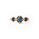 Crafted in 14KT yellow gold, this ring features a blue sapphire set between two smaller ones on a vintage-inspired hand engraved band.