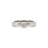Crafted in 14KT white gold, this ring features a bezel set round brilliant-cut diamond and a flat band.
