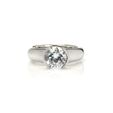 Crafted in 14KT white gold, this ring features a round-cut diamond in a half-bezel setting. 