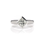 Crafted in 14KT white gold, this ring features a bezel set princess-cut diamond.