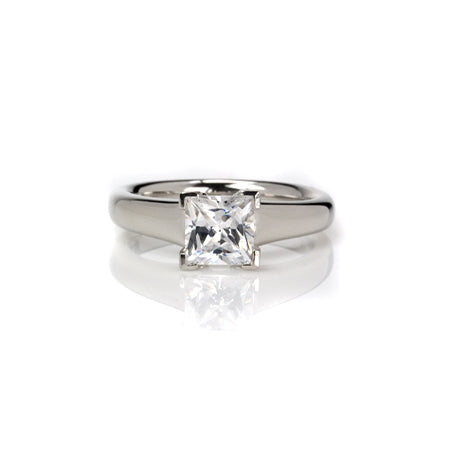  Crafted in 14KT white gold, this ring features a princess-cut diamond with v-shaped prongs holding it in place. 