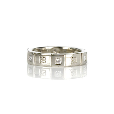 Crafted in 14KT white gold, this ring features six raised sections, each set with a princess-cut diamond. Alternating with hand-engraved orange blossoms in square settings.