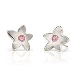Crafted in 14KT white gold, these stud earrings each feature a flower with a pink sapphire centre.
