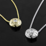 A 14KT white gold and a 14KT yellow gold ‘Opulence Paisley Hand-engraved Diamond Pendant’ are shown side by side.