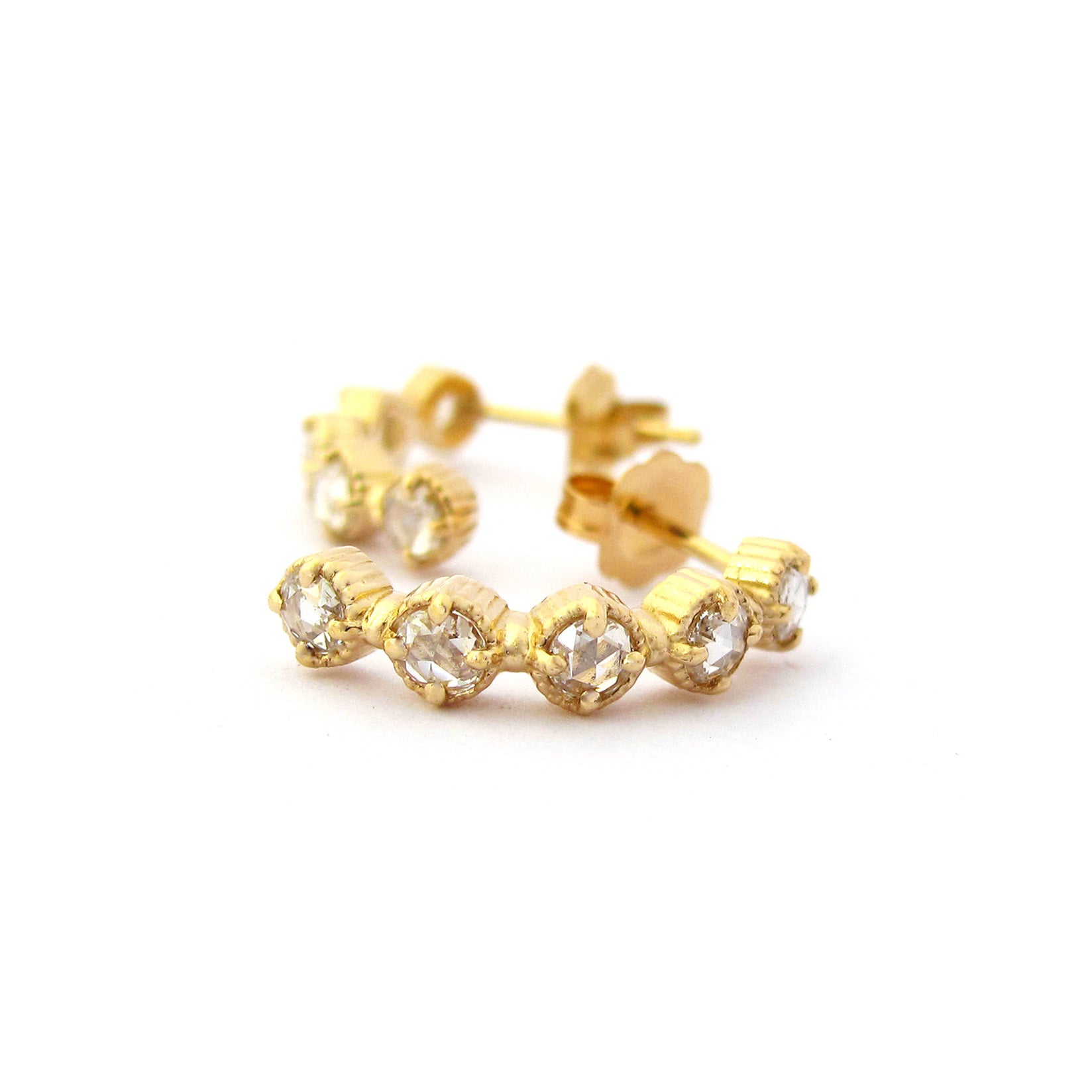 Crafted in 14KT yellow gold, these half-hoop earrings feature five rose-cut diamonds each in cupcake settings.