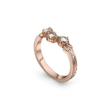 Crafted in 14KT rose gold, this ring has a curve featuring 3 rose-cut diamonds in a row on a vintage-inspired hand engraved band.