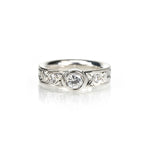 Crafted in 14KT white gold, this comfort-fit ring is set with a round brilliant-cut diamond between two smaller round brilliant-cut diamonds on a paisley hand-engraved band.