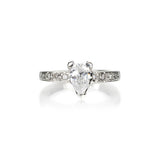 Crafted in 14KT white gold, this ring features a pear-shape diamond in a three prong setting on an orange blossom hand-engraved band set with round-cut diamonds.