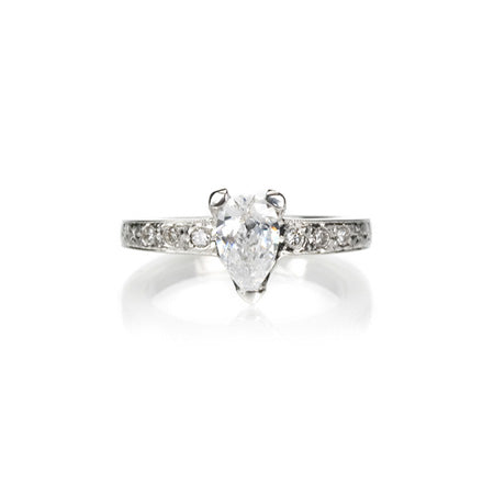 Crafted in 14KT white gold, this ring features a pear-shape diamond in a three prong setting on an orange blossom hand-engraved band set with round-cut diamonds.