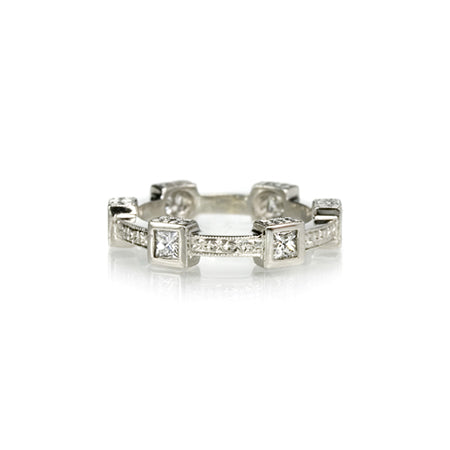 Crafted in 14KT white gold, this ring features six princess-cut diamonds in square bezels and flat edges with orange blossom hand-engravings.