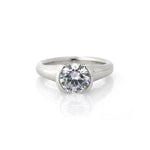 Crafted in 14KT white gold, this ring features a half-bezel set round brilliant-cut diamond with signature trademark on both sides.