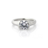 Crafted in 14KT white gold, this ring features a half-bezel set round brilliant-cut diamond with signature trademark on both sides.