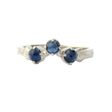 Crafted in 14KT white gold, this wrap-around ring features a curve set with 3 regal sapphires on a vintage-inspired hand engraved band.
