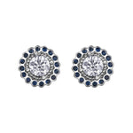 Crafted in 18KT white Canadian Certified Gold, these stud earrings feature regal blue sapphire halos with round brilliant-cut Canadian centre diamonds.