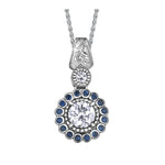 Crafted in 14KT white Canadian Certified Gold, this necklace features a regal blue sapphire halo with a round brilliant-cut Canadian centre diamond with a frost-inspired hand engraved bail.