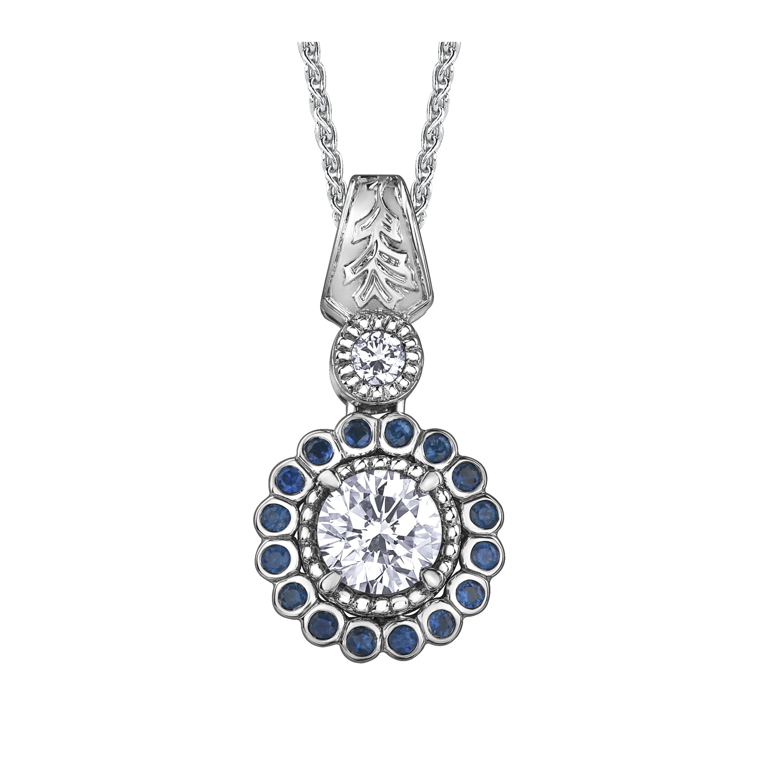 Crafted in 14KT white Canadian Certified Gold, this necklace features a regal blue sapphire halo with a round brilliant-cut Canadian centre diamond with a frost-inspired hand engraved bail.