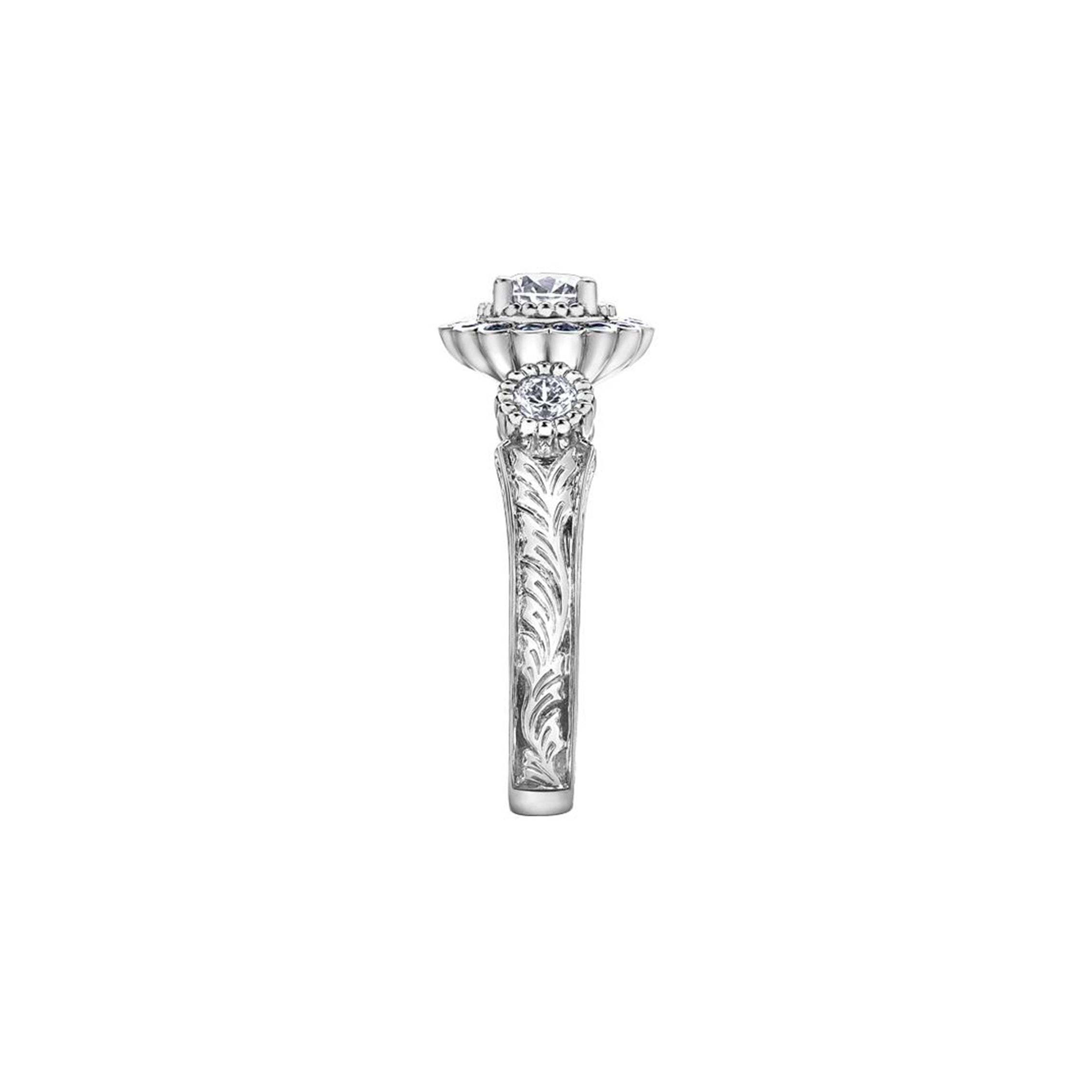 Crafted in 18KT white Canadian Certified Gold, this ring features a regal blue sapphire halo with a round brilliant-cut Canadian centre diamond on a frost-inspired hand engraved band.