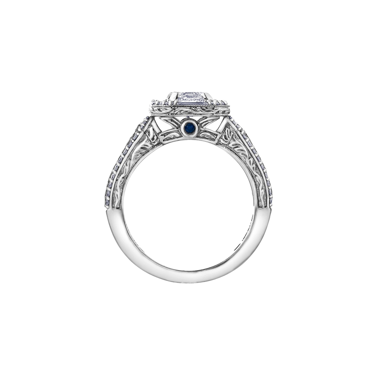 Crafted in 18kt Pure White™, this ring features an emerald-cut Canadian centre diamond framed by round and baguette-cut diamonds on a frost-inspired hand engraved band with a blue sapphire detail.