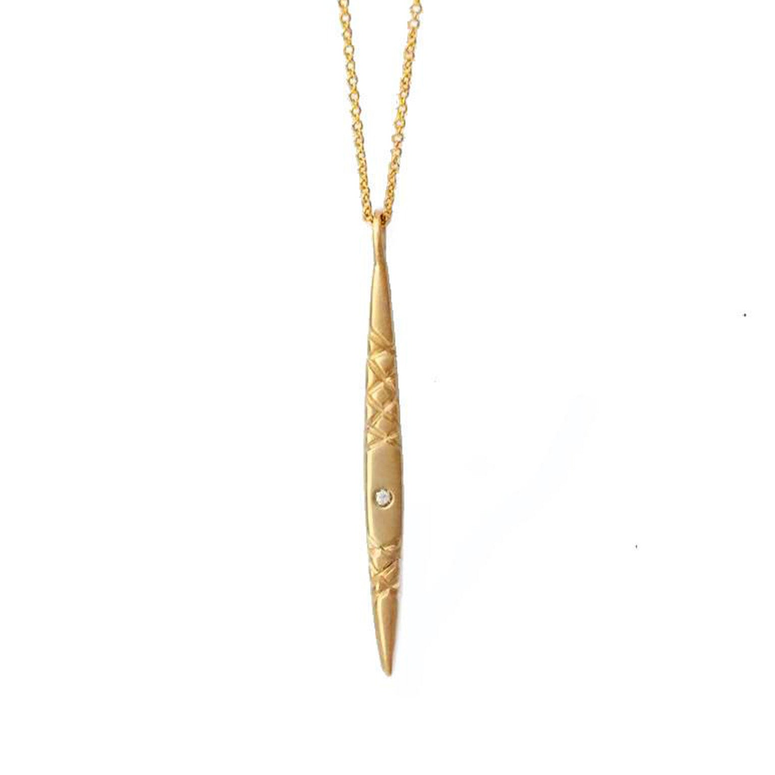 Crafted in 14KT yellow gold, this spear inspired pendant features a round white diamond and quilted details.