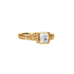 Crafted in 14KT gold this engagement ring features a bezel set princess-cut on an orange blossom hand-engraved band.