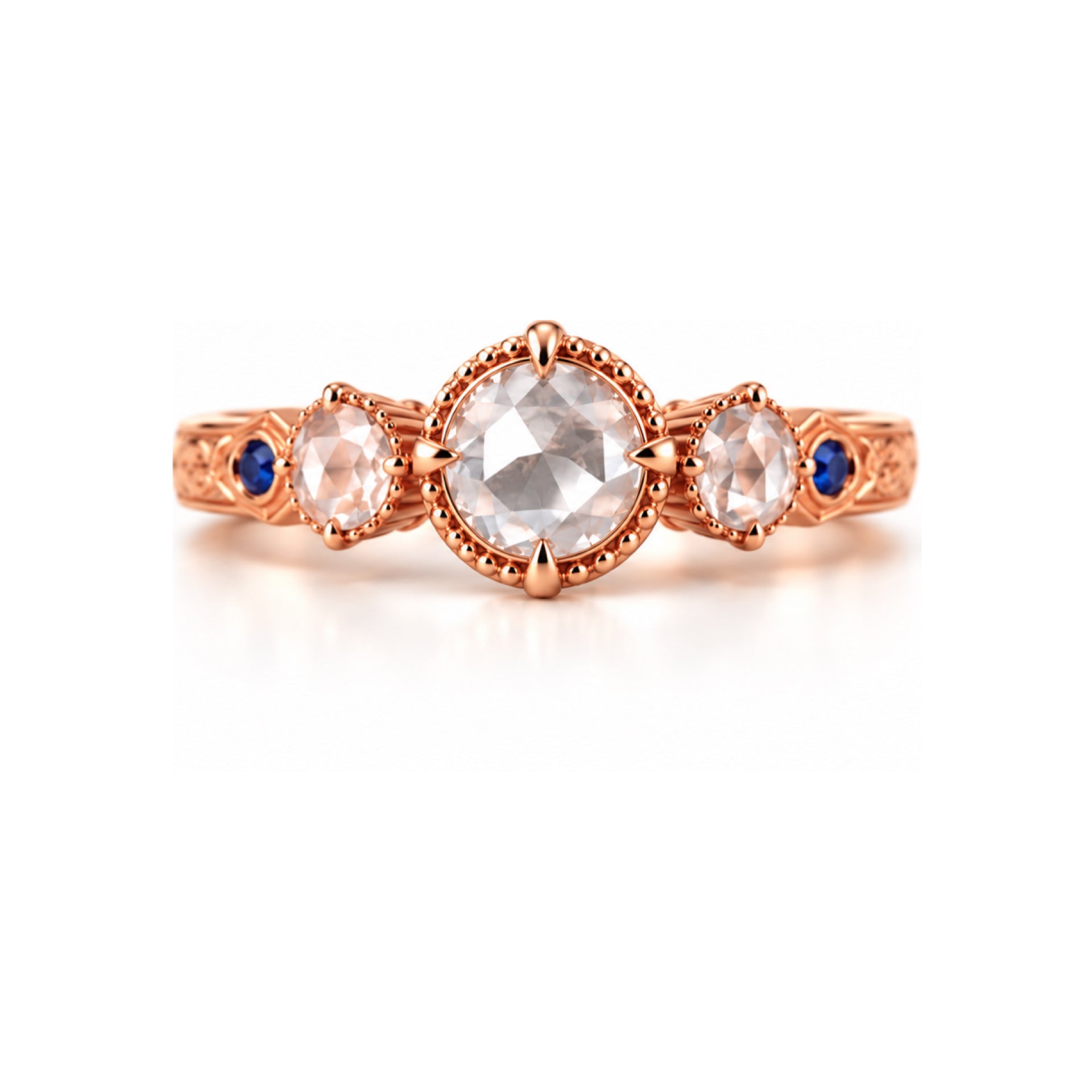 A rose gold three-stone ring featuring a large round center stone and two smaller round side stones, accented with tiny blue gemstones on the band, set against a clean white background.