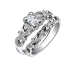 18kt gold engagement ring with oval-cut Canadian diamond, diamond side stones, and intricate rose vine detailing, 0.45 TDW.