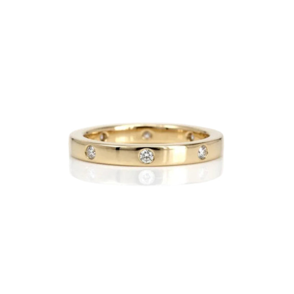 Crafted in 14KT gold, this ring features eight round brilliant-cut diamonds evenly spaced apart on a flat band.