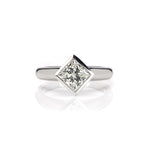 Crafted in 14KT gold, this engagement ring features a bezel set princess-cut diamond. 