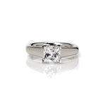  Crafted in 14KT gold, this engagement ring features a princess-cut diamond with v-shaped prongs holding it in place. 