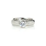 Crafted in 14KT gold, this engagement ring features a bezel set round brilliant-cut diamond. 