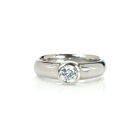 Crafted in 14KT gold, this engagement ring features a bezel set round brilliant-cut diamond. 