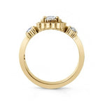 A yellow gold ring featuring a central round clear gemstone in a prong setting, with two smaller round clear gemstones on either side of the band, shown on a plain white background.
