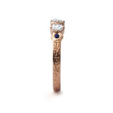 Crafted in 14KT yellow gold, this ring features 3 round brilliant-cut diamonds in a row, with a blue sapphire on either side on a vintage-inspired hand engraved band.