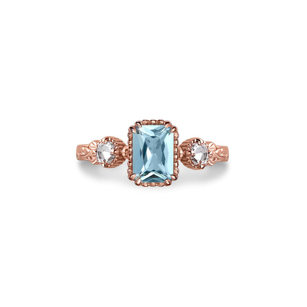 Crafted in 14KT rose gold, this ring features an aquamarine between two round brilliant-cut diamonds on a vintage-inspired hand engraved band.
