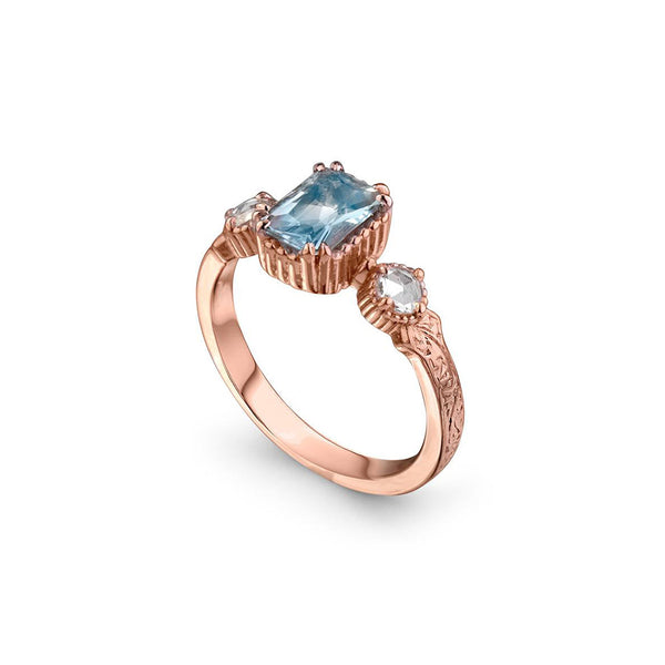 Crafted in 14KT rose gold, this ring features an aquamarine between two round brilliant-cut diamonds on a vintage-inspired hand engraved band.
