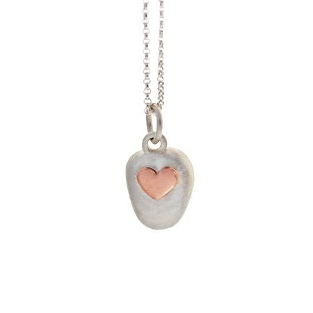 Crafted in brushed sterling silver, this smooth, organically shaped pendant features an oval set with a small 14KT rose gold heart.