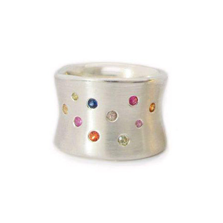Crafted in brushed sterling silver, this smooth, organically shaped 14mm wide band is studded with an array of unique multi-coloured sapphires.