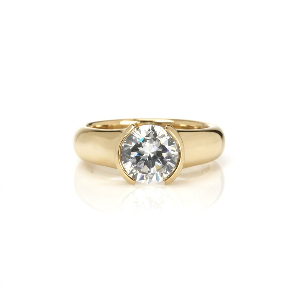 Crafted in 14KT gold, this engagement ring features a round-cut diamond in a half-bezel setting. 