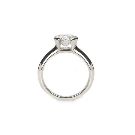Crafted in 14KT white gold, this ring features a round-cut diamond in a half-bezel setting. 