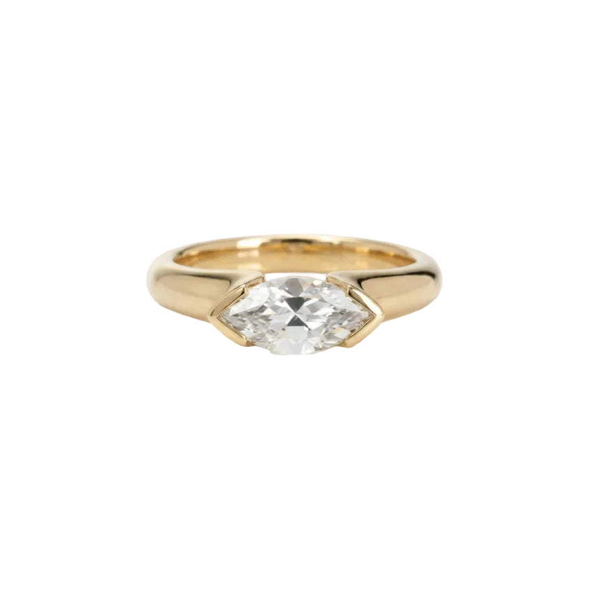 Crafted in 14KT gold, this engagement ring features a half-bezel set marquise-cut diamond horizontally on the band. 
