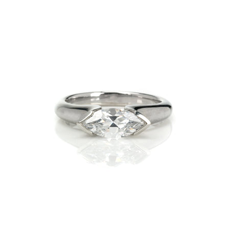 Crafted in 14KT white gold, this ring features a half-bezel set marquise-cut diamond horizontally on the band. 