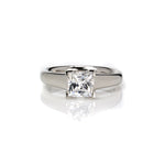  Crafted in 14KT white gold, this ring features a princess-cut diamond with v-shaped prongs holding it in place. 