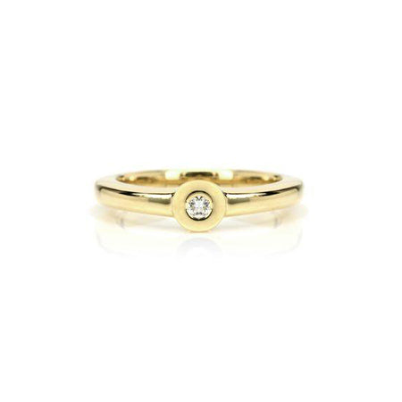 Crafted in 14KT yellow gold, this ring features a bezel set round brilliant-cut diamond with a flat halo.
